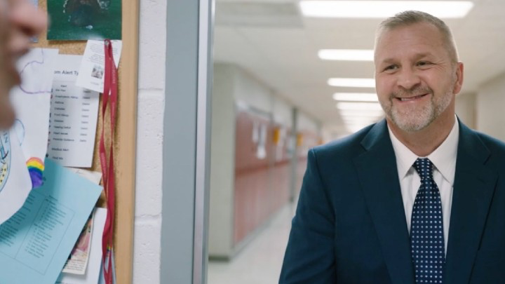 Cumberland School District superintendent smiling in school hallway.